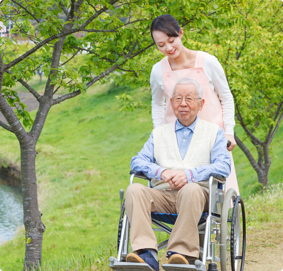 Senior man sitting on a wheelchair with caregiver